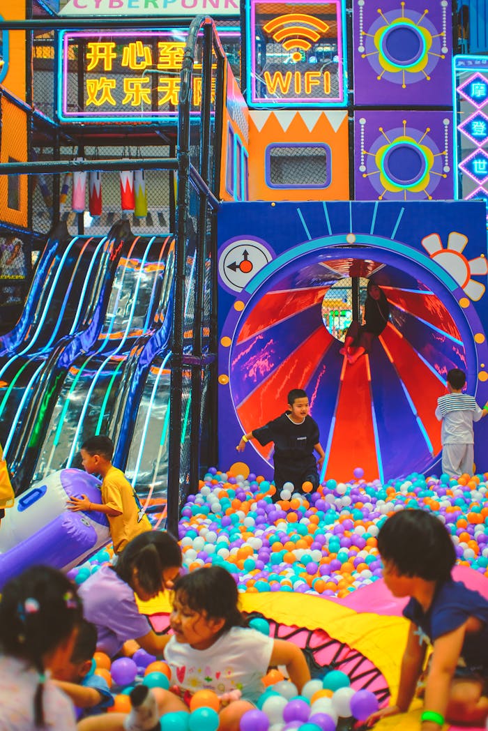 Children enjoying a vibrant indoor playground with slides and ball pit.