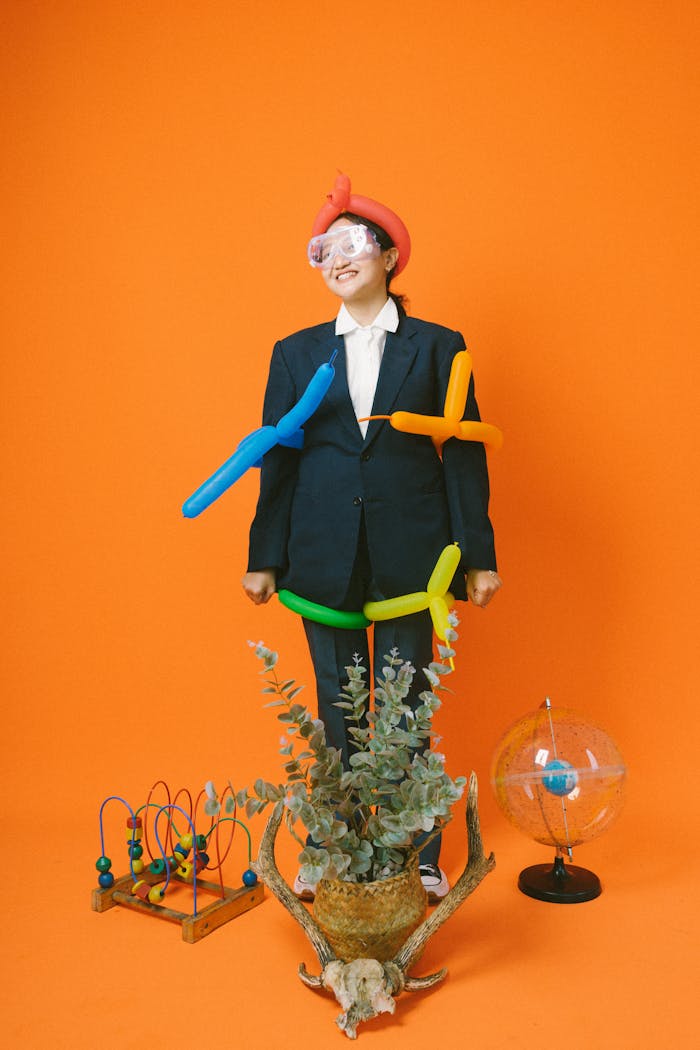 A person in a playful balloon costume against an orange backdrop, symbolizing creativity.